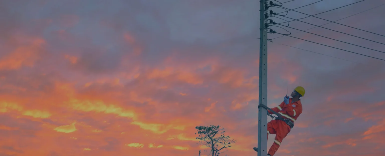 Man climbing an electric pole to perform routine maintenance
